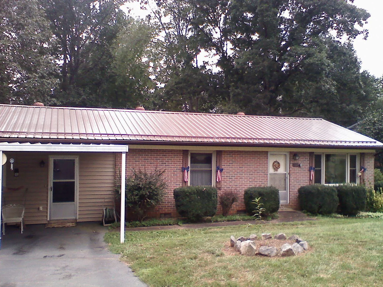 Bronze metal roof and carport on a brick ranch home — Roof Repair work by our crew in Versailles